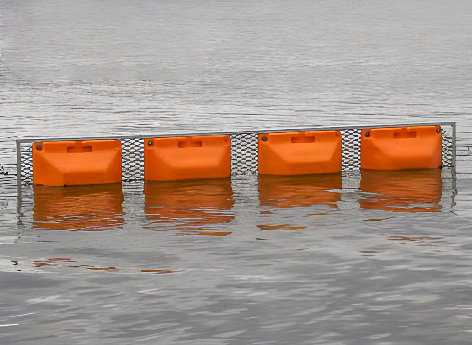 Steel Mesh Boom for Heavy-Duty Debris Containment Orange Steel Mesh debris Boom floating in water with rigid metal framework for heavy-duty floating debris containment.